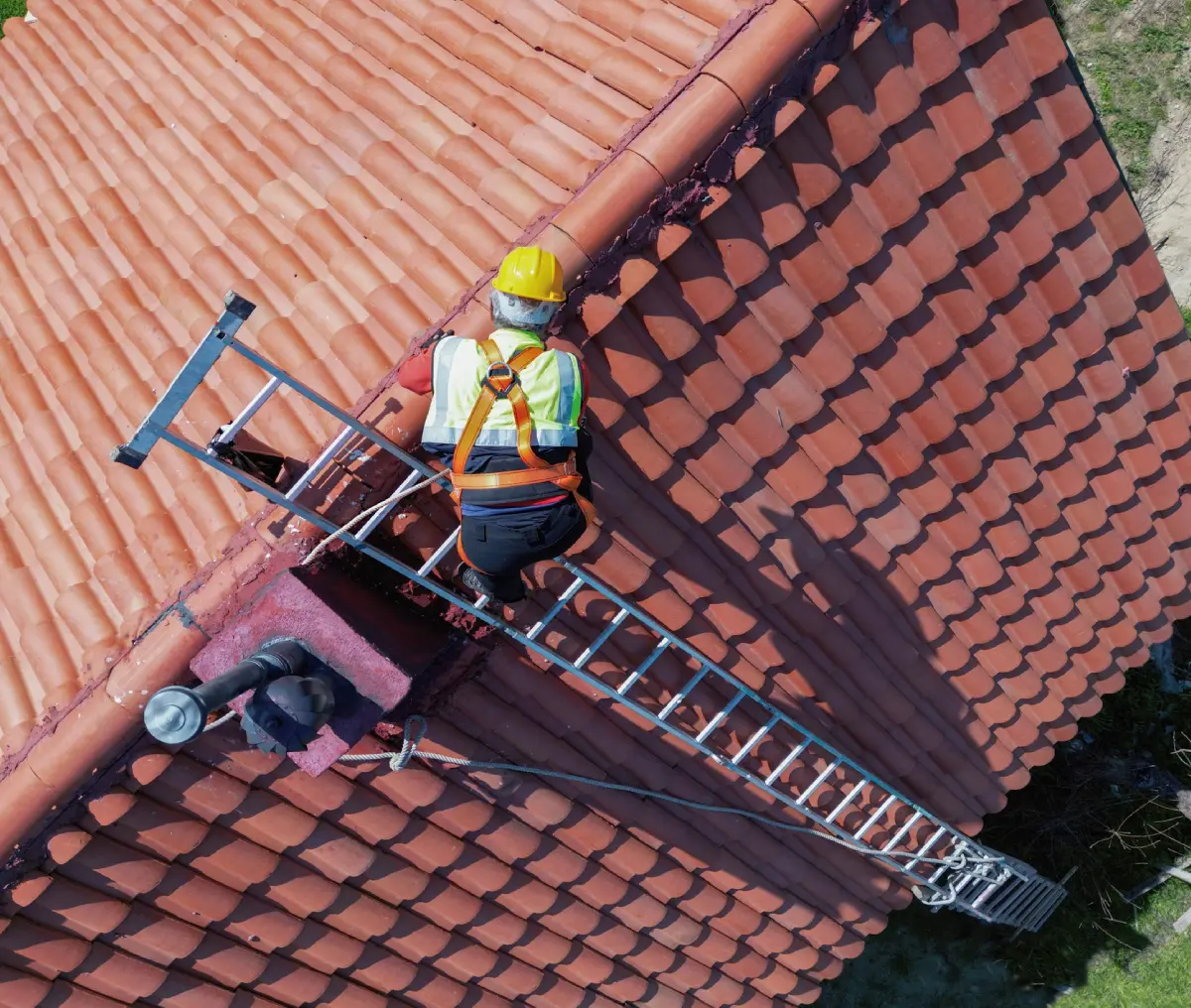 Roofer repairing red tile rooftop