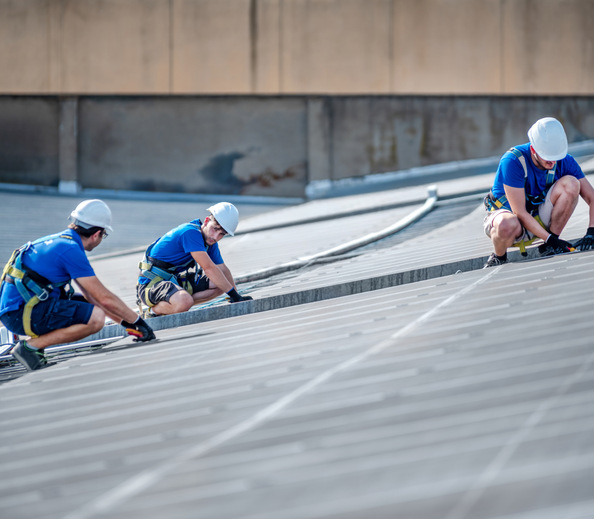 Construction workers securing rooftop cables